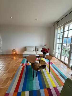 a living room with a couch and a table on a colorful rug at Spacieux et lumineux 2 chambres vue mer Centre-ville de Porto-Vecchio in Porto-Vecchio