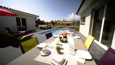 a table with plates of food sitting on a patio at Villa Suarticcia, 6 pers, piscine chauffée, 3 min plage en voiture in Sainte-Lucie de Porto-Vecchio
