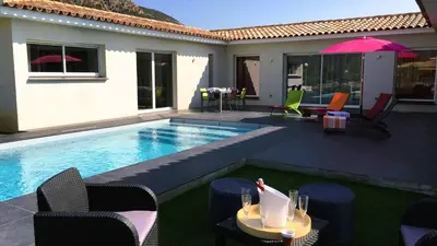 a pool with chairs and a table with an umbrella at Villa Suarticcia, 6 pers, piscine chauffée, 3 min plage en voiture in Sainte-Lucie de Porto-Vecchio