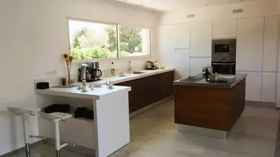 a large white kitchen with a counter and a window at Villa Suarticcia, 6 pers, piscine chauffée, 3 min plage en voiture in Sainte-Lucie de Porto-Vecchio