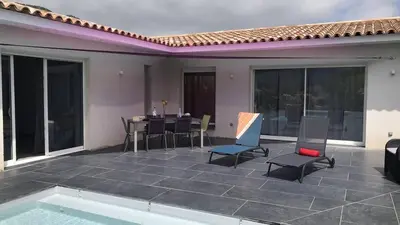 a patio with a table and chairs and a pool at Villa Suarticcia, 6 pers, piscine chauffée, 3 min plage en voiture in Sainte-Lucie de Porto-Vecchio
