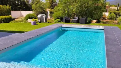a swimming pool with blue water in a yard at Villa Suarticcia, 6 pers, piscine chauffée, 3 min plage en voiture in Sainte-Lucie de Porto-Vecchio