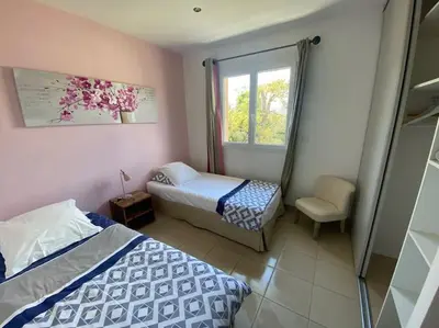 a bedroom with two beds and a window at Maison jasmin Porto Vecchio in Porto-Vecchio