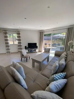 a living room with a brown couch and a table at Maison jasmin Porto Vecchio in Porto-Vecchio