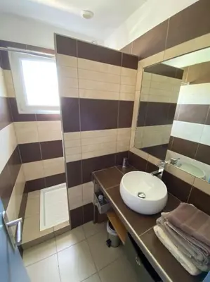 a bathroom with a sink and a toilet and a mirror at Maison jasmin Porto Vecchio in Porto-Vecchio