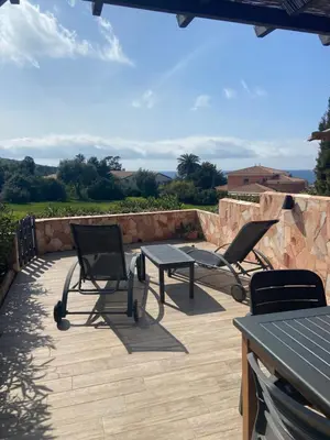 a patio with two chairs and a table and a bench at Maison mer piscine Cargese à 1 heure d'Ajaccio in Cargèse
