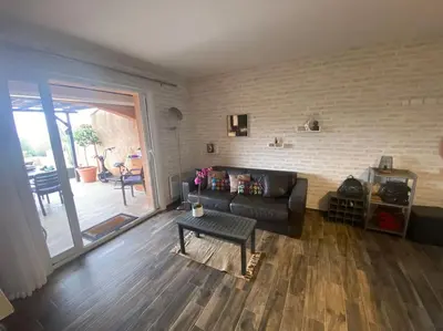 a living room with a leather couch and a table at Maison mer piscine Cargese à 1 heure d'Ajaccio in Cargèse