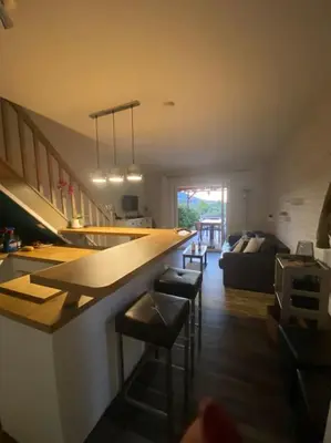 a kitchen with a bar with stools and a living room at Maison mer piscine Cargese à 1 heure d'Ajaccio in Cargèse