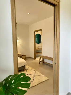 a room with a mirror and a bedroom with a bed at Villa vue sur le Golf 1 in Olmeto