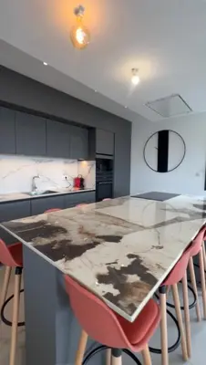 a kitchen with a marble counter top and red stools at Villa vue sur le Golf 1 in Olmeto
