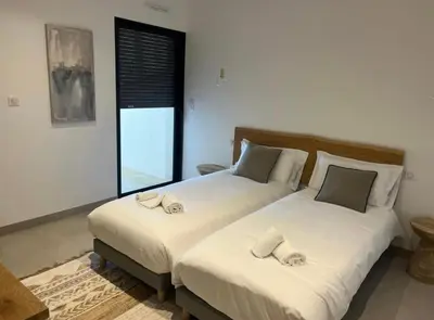 a bedroom with two beds with white sheets and a window at Villa vue sur le Golf 1 in Olmeto