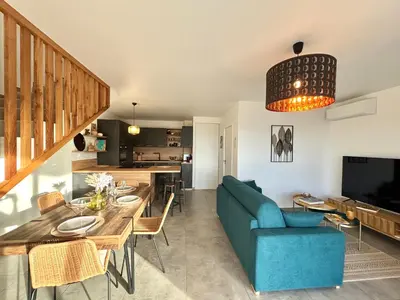 a living room with a blue couch and a table at Duplex Tour d'Omigna Cargèse in Cargèse