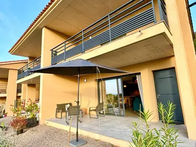 an umbrella on a patio in front of a building at Duplex Tour d'Omigna Cargèse in Cargèse