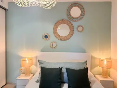 a bedroom with a bed with two lamps and mirrors at Nouveauté ! Bel'Orizonte T - Deux Chambres proche mer in Propriano