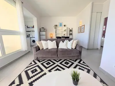 a living room with a couch and a kitchen at La Perla di Santa Maria - Vue mer, plage à 100 m in Santa-Maria-Poggio