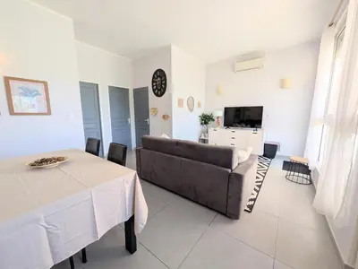a living room with a couch and a table at La Perla di Santa Maria - Vue mer, plage à 100 m in Santa-Maria-Poggio