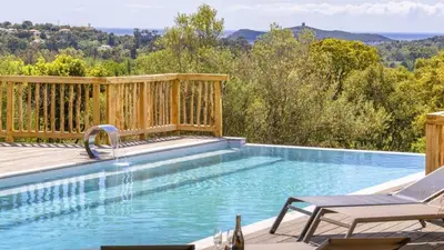 a swimming pool with a wooden deck and a swimming poolvisor at Villa Gaïa, 6 pers, piscine chauffée, 3 min plage in Sainte-Lucie de Porto-Vecchio