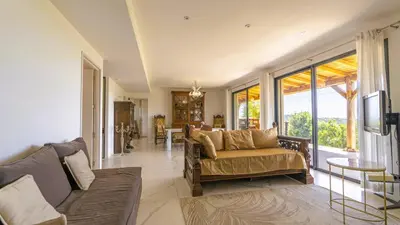 a living room with a couch and a table at Villa Gaïa, 6 pers, piscine chauffée, 3 min plage in Sainte-Lucie de Porto-Vecchio