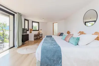 a large white bedroom with a large bed and a desk at Villa Puccinelli in Porto-Vecchio