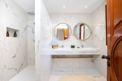 a bathroom with a sink and two mirrors at Villa Puccinelli in Porto-Vecchio