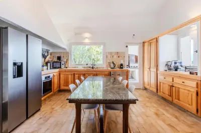 a kitchen with a table and a stainless steel refrigerator at Villa Puccinelli in Porto-Vecchio