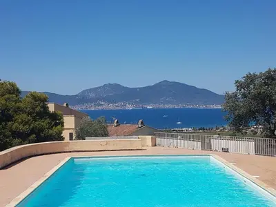 a large swimming pool with a view of the water at Maisonnette vue mer résidence vacances Porticcio in Grosseto-Prugna