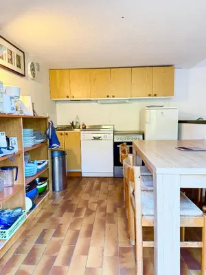a kitchen with wooden cabinets and a wooden floor at Maisonnette vue mer résidence vacances Porticcio in Grosseto-Prugna