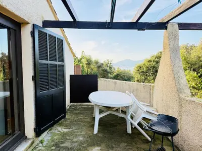 a table and chairs on the balcony of a house at Maisonnette vue mer résidence vacances Porticcio in Grosseto-Prugna