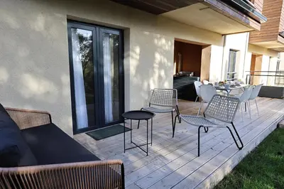 a patio with chairs and a couch and a table at Casa 115 - Plage & piscine chauffée in Pianottoli-Caldarello