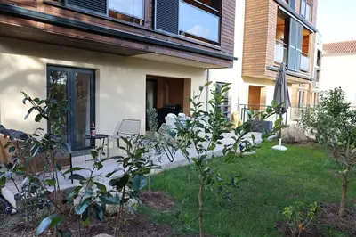a house with a patio and a yard with plants at Casa 115 - Plage & piscine chauffée in Pianottoli-Caldarello