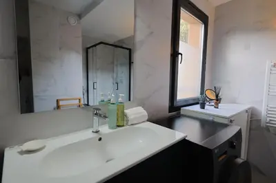 a bathroom with a white sink and a mirror at Casa 115 - Plage & piscine chauffée in Pianottoli-Caldarello