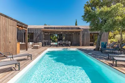 a swimming pool with a deck and a house at A Casedda Serena Di lecci in San-Gavino-di-Carbini