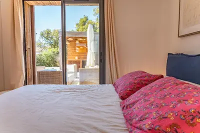 a bedroom with a bed with a view of a patio at A Casedda Serena Di lecci in San-Gavino-di-Carbini