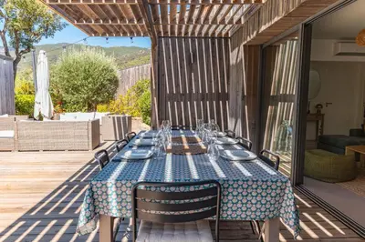 a table with plates and glasses on a patio at A Casedda Serena Di lecci in San-Gavino-di-Carbini