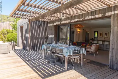 a patio with a table and chairs on a deck at A Casedda Serena Di lecci in San-Gavino-di-Carbini