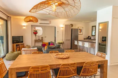 a dining room and living room with a table and chairs at A Casedda Serena Di lecci in San-Gavino-di-Carbini