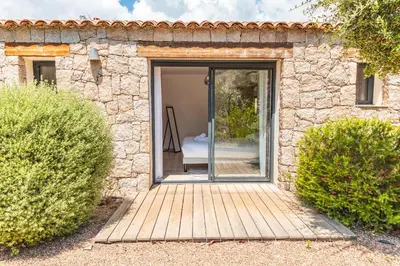 a door leading to a patio in a stone house at Casa Di Sole Di Pinarello in Pinarellu