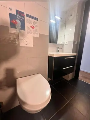 a bathroom with a white toilet and a sink at Duplex Vista in Bonifacio