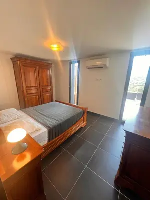 a bedroom with a bed and a table and a window at Duplex Vista in Bonifacio