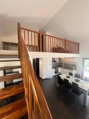 a dining room with a staircase and a table and chairs at Duplex Vista in Bonifacio