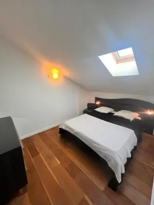 a bedroom with a bed and a skylight at Duplex Vista in Bonifacio