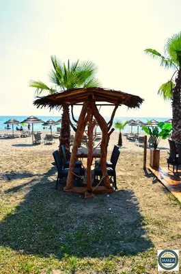 a wooden table and chairs on the beach at Bungalow on the sea - Moriani beach in Santa-Lucia-di-Moriani