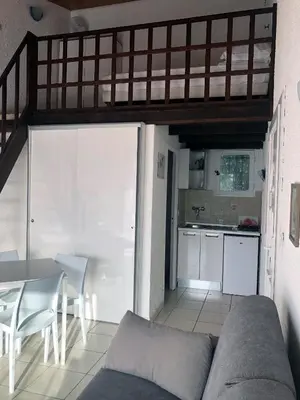 a living room with a couch and a table and a kitchen at Bungalow on the sea - Moriani beach in Santa-Lucia-di-Moriani