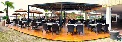 a restaurant with tables and chairs and umbrellas at Bungalow on the sea - Moriani beach in Santa-Lucia-di-Moriani