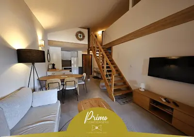 a living room with a couch and a television and a table at Perla di Mare - T3 avec piscine et accès plage in Viagenti