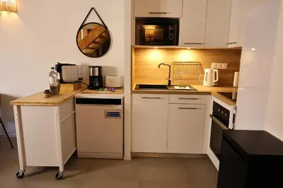 a small kitchen with white cabinets and a sink at Perla di Mare - T3 avec piscine et accès plage in Viagenti