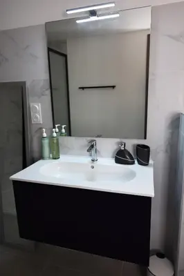 a bathroom with a white sink and a mirror at Perla di Mare - T3 avec piscine et accès plage in Viagenti