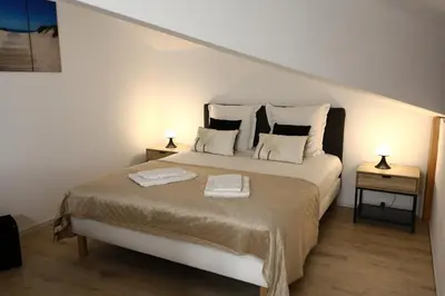 a white bedroom with a bed with two night stands at Perla di Mare - T3 avec piscine et accès plage in Viagenti