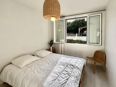 a bedroom with a bed and a window at Appartement vue sur les toits de Propriano in Propriano