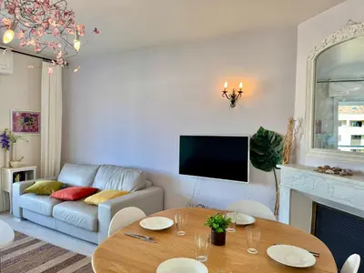 a living room with a table and a couch at Appartement vue sur les toits de Propriano in Propriano